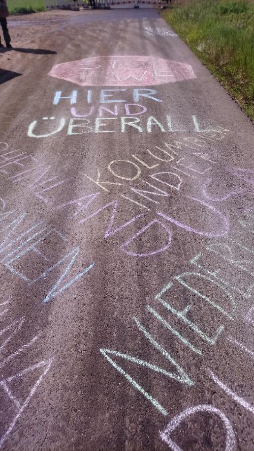 L12 mit einer Kreideaufschrift Stop RWE Hier und überall Kolumbien, Indien, Rheinland, Niederlande, Spanien.